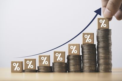 Increasing coin stacking with up arrow and percentage sign for increase financial interest rate and business investment growth from dividend concept.