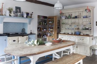 Kitchen with blue and cream units, an aga and wooden kitchen table and chairs