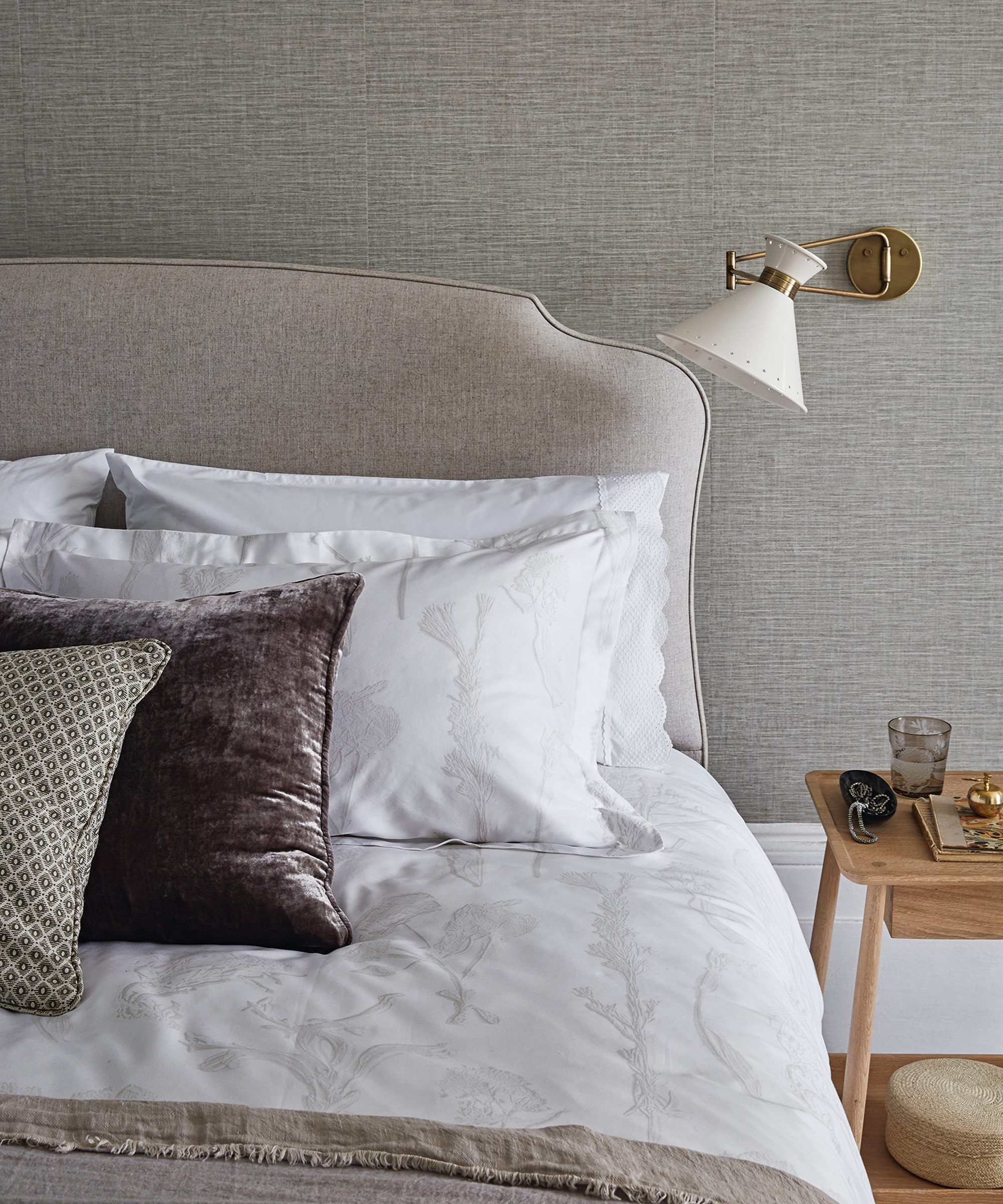 A grey bedroom idea with pale grey wall panels and large mirror over a marble fireplace