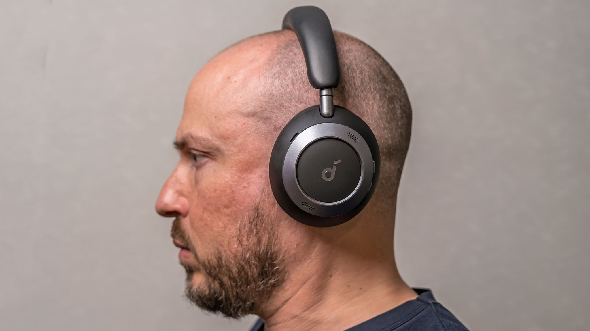 Side profile view of Soundcore Space Pro One headphones on man's head.