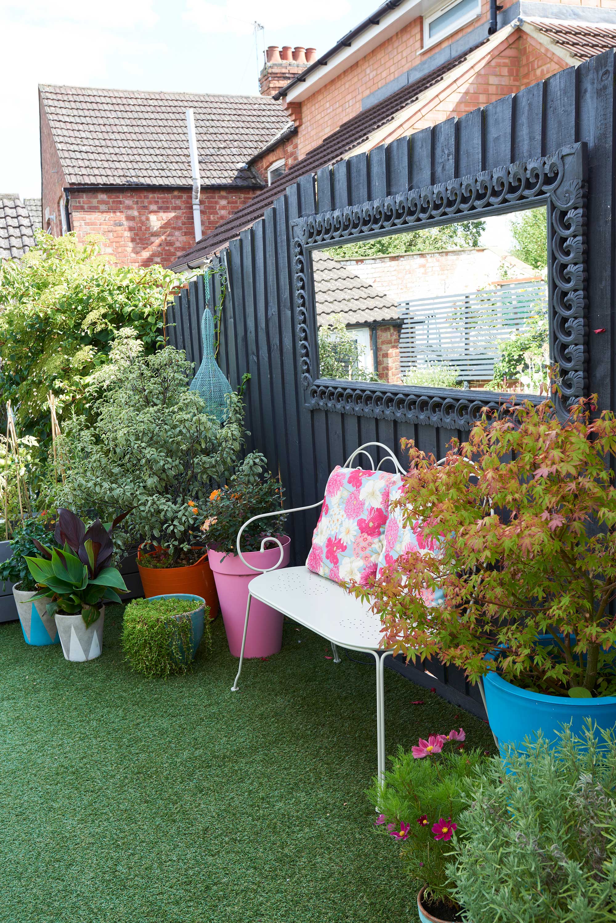 black fence with mirror above bench