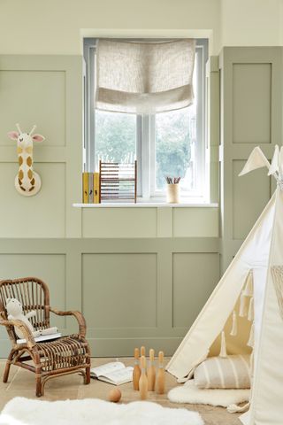 Playroom ideas illustrated with three shades of green and a mix of white and cream room decorations including a teepee and fluffy rugs.