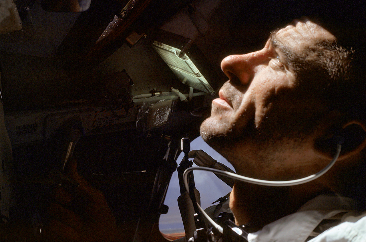 Apollo 7 astronaut Walt Cunningham, lunar module pilot, looks out the window of the Apollo command module in Earth orbit.