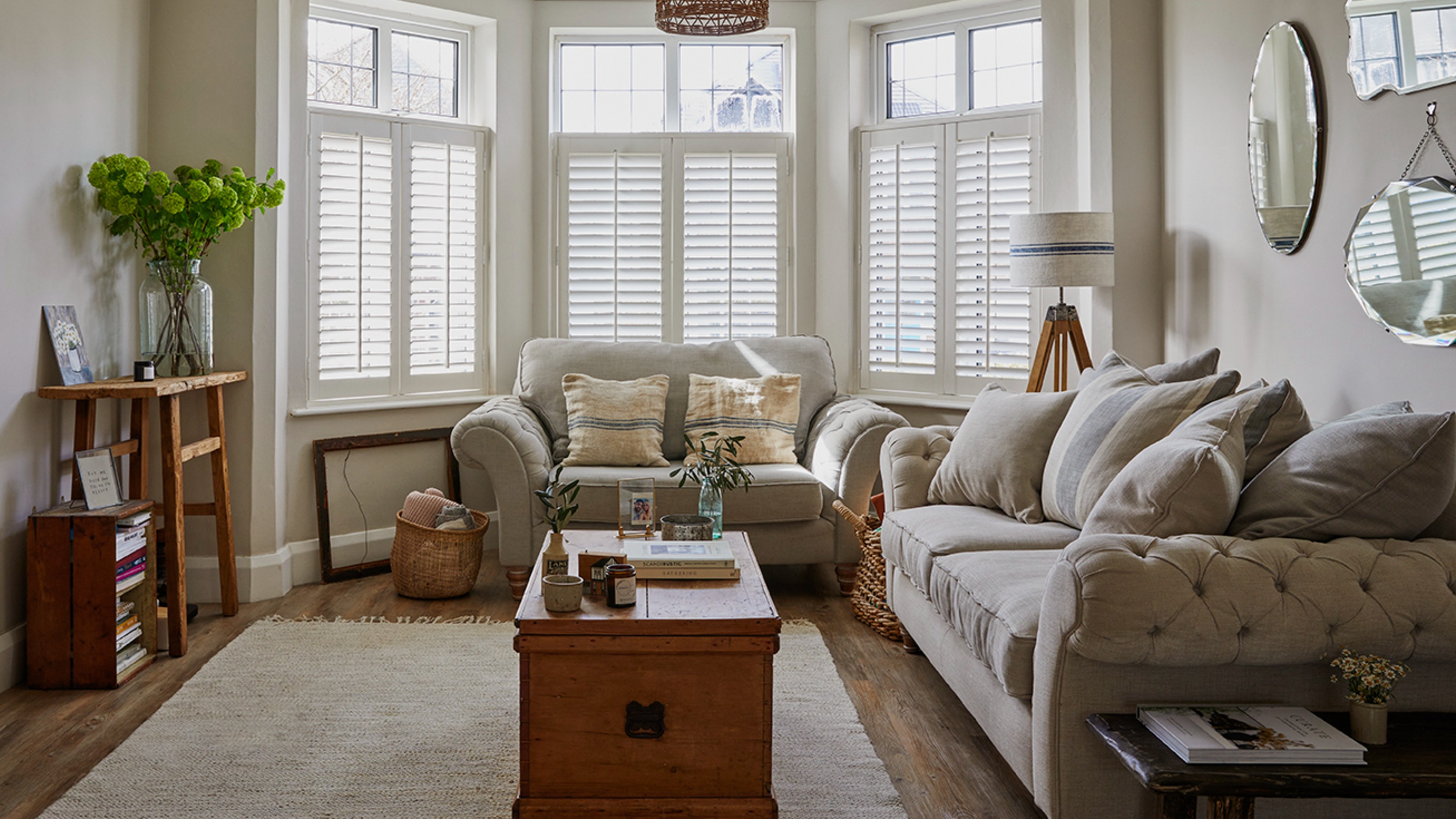 A neutral living room with a Chesterfield light grey sofa and a matching loveseat