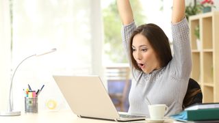 mujer contenta usando un portátil con Windows 10 