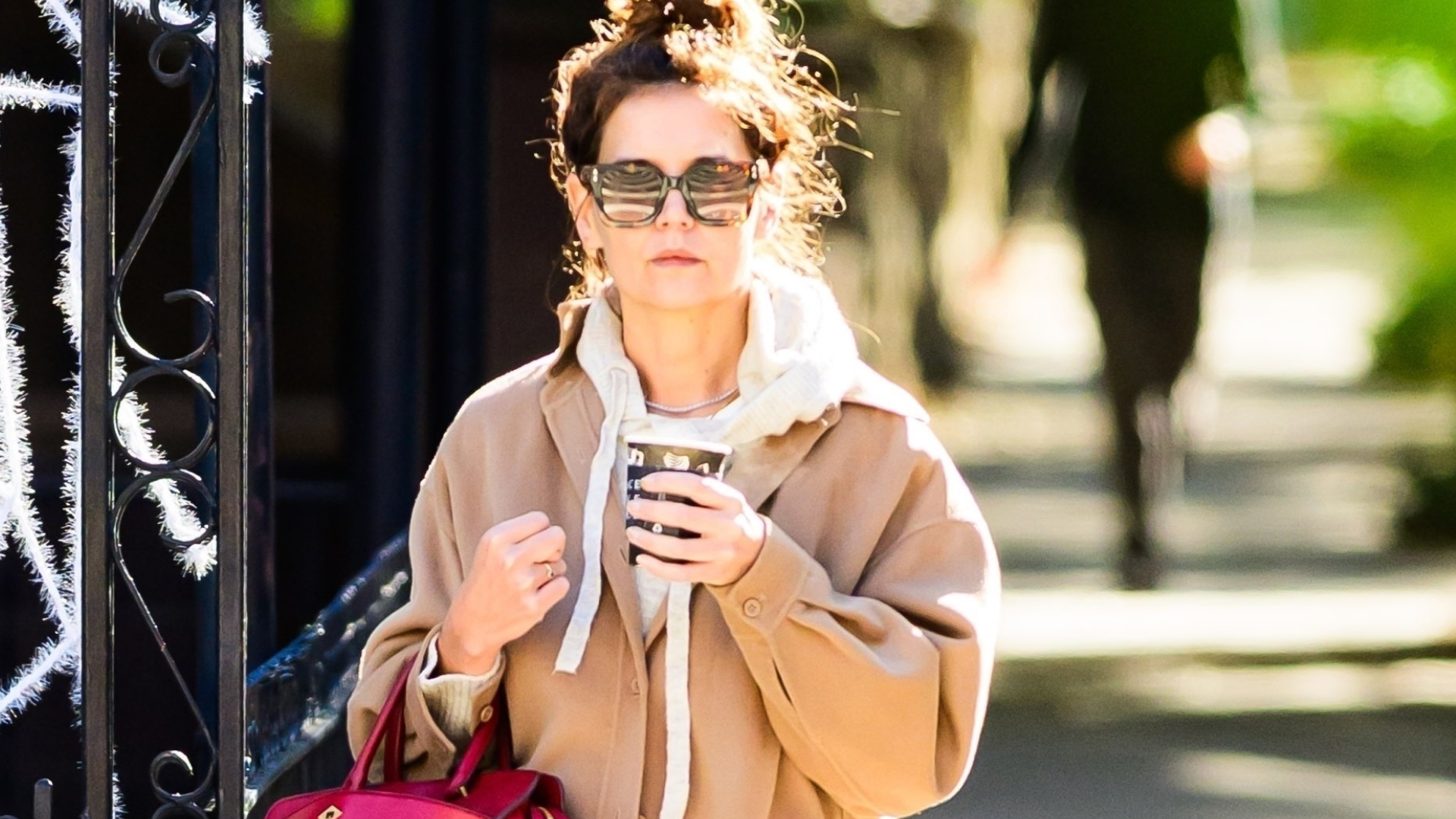Katie Holmes carrying her Metier red bag and wearing wide-leg jeans and Autry sneakers