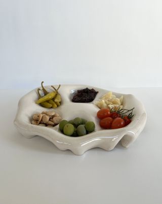 a white ceramic snack plate with charcuterie on