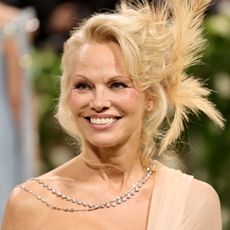 pamela anderson smiles wearing a crystal necklace at the 2024 met gala