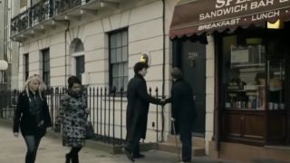 Sherlock and Dr. Watson meeting outside his apartment in front of Speedy's