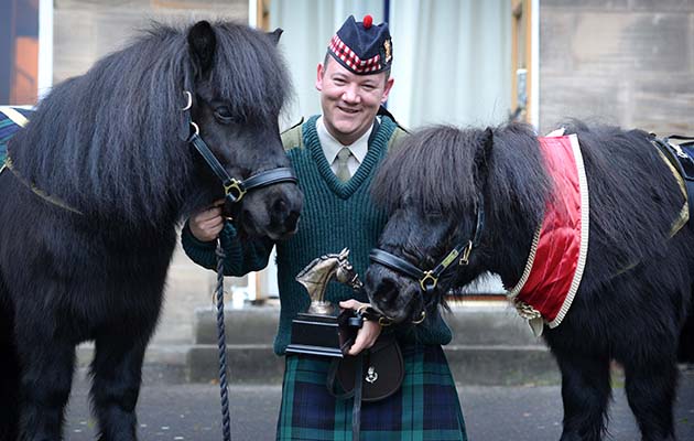 Major Corporal Mark Wilkinson, who is responsible for the care, training and welfare of Cruachan III (right) is joined by Cruachan IV (left) at the ceremony in Edinburgh today. Shetland pony and former Royal Regiment of Scotland Mascot &amp;lsquo;Cruachan III&amp;rsquo; was awarded the &amp;lsquo;Tarragon Trophy&amp;rsquo; from The British Horse Society today at a special event held in Redford Barracks in Edinburgh. The &amp;lsquo;Tarragon Trophy&amp;rsquo; is the British Horse Society &amp;lsquo;Equine Personality&amp;rsquo; of the year award and is presented to horses or ponies that have contributed to the community, overcome hardship or deemed to have the personality worthy of the esteemed honour. Helene Mauchlen from the British Horse Society, said: &amp;ldquo;Every so often the BHS is privileged to meet an equine that has delivered untold benefit to humankind, and Cruachan is just that pony. &amp;ldquo;In his long life he has brightened the lives of so many people, from casual acquaintances at events, veterans and sick children and on top of that he does his day job of representing, inspiring and motivating our army. &amp;ldquo;He is a credit to all equines and an example of the untold good that horses and ponies provide. It is our pleasure and a privilege to present him with the Tarragon Trophy.&amp;rdquo; Shetland pony, Cruachan III, retired in 2012 at the age of 23 after nearly two decades of military service. For almost 17 years he took part in numerous military parades, Highland games and became a much loved addition to the cast of the Royal Edinburgh Military Tattoo. The endearing pony was also a personal favourite of Her Majesty The Queen and attended Balmoral Castle each year when she visited Scotland. Colonel Alastair Campbell, Regimental Secretary of The Royal Regiment of Scotland, said: &amp;ldquo;Cruachan III marched proudly with Scottish infantry soldiers on parade for 17 years, firstly with the Argyll and Sutherland Highlanders and then The Royal Regiment of Scotland. So we are extremely pleased that the British H
