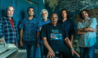 A photo of the band Little Feat in 2025. Keyboardist Bill Payne is at far left, multi-instrumentalist (guitar, mandolin, and trumpet) Fred Tackett is back middle left, and guitarist Scott Sharrard is back middle right