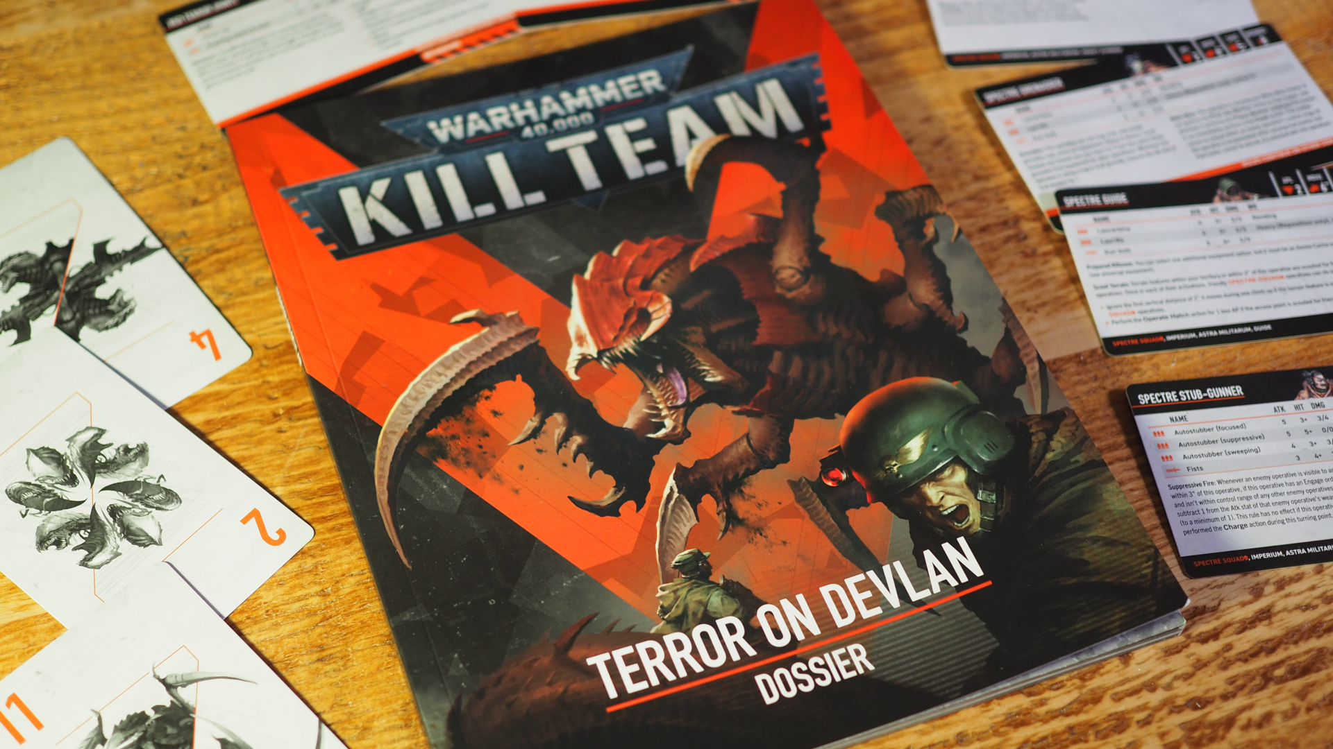 Kill Team: Terror on Devlan book and cards on a wooden surface