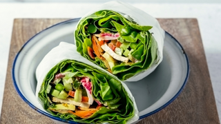 two lettuce wraps on a white plate on a chopping board