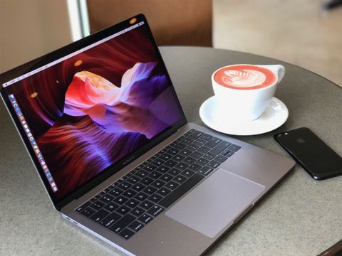 MacBook Pro with a cup of coffee and iPhone