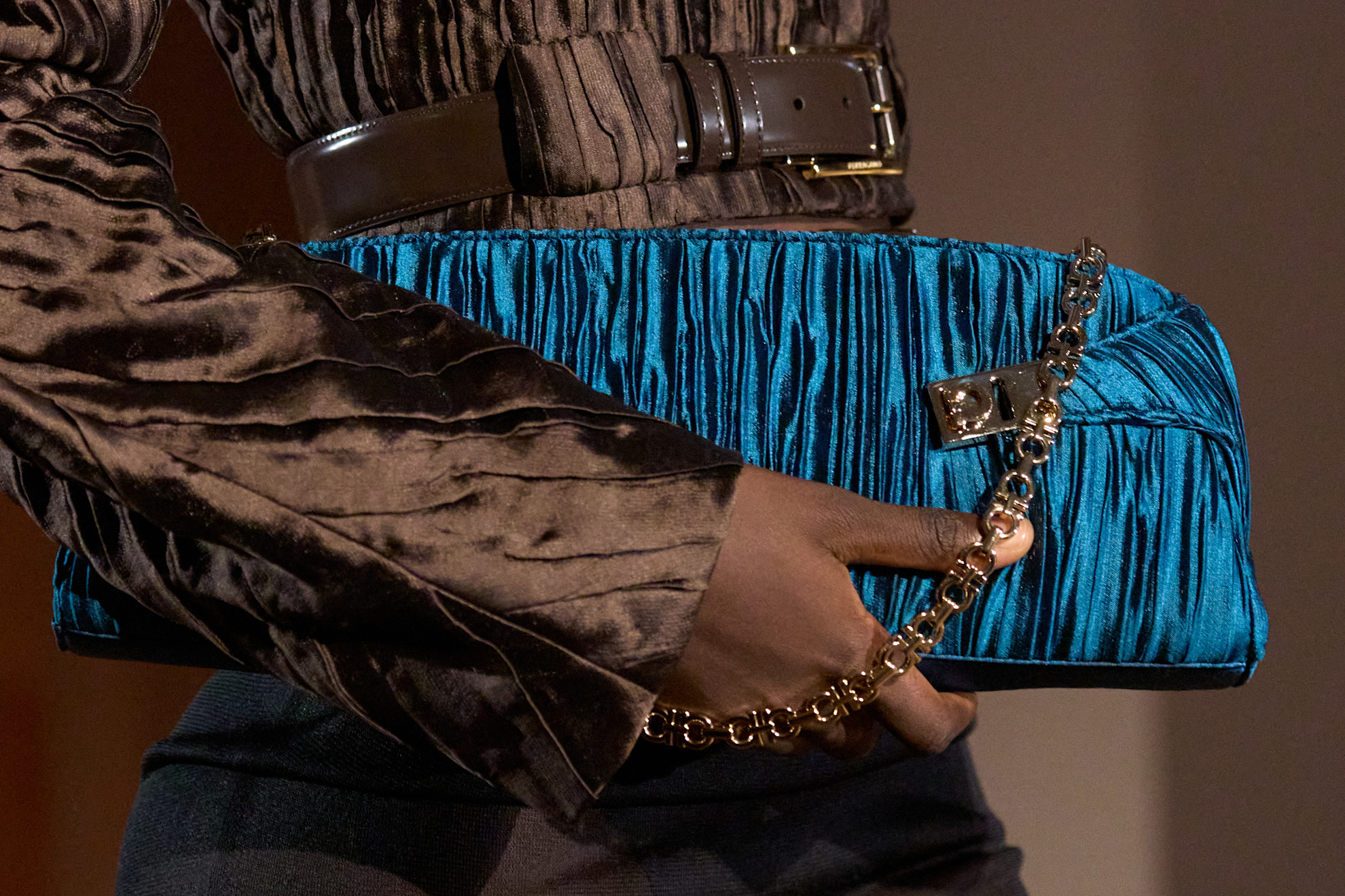 a woman carries a clutch bag at the ferragamo spring 2027 show.