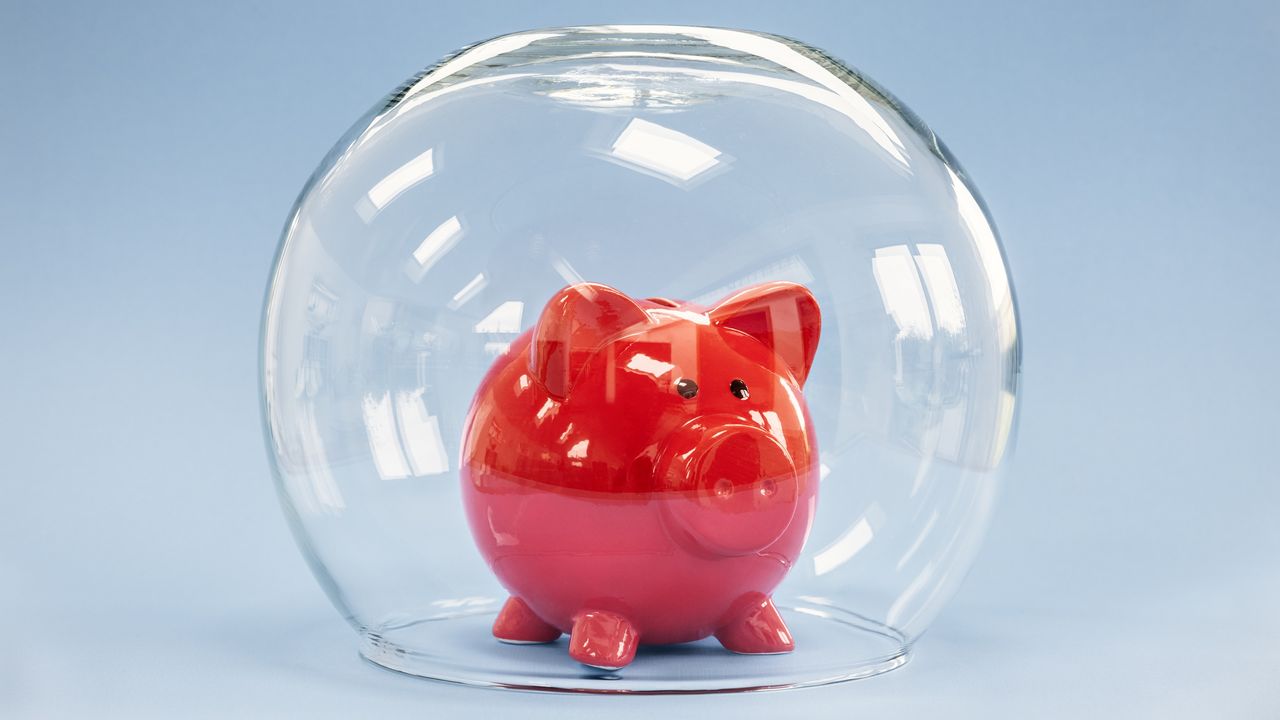 A piggy bank inside a glass bubble.