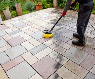 Cleaning stone slabs on patio with the high-pressure cleaner