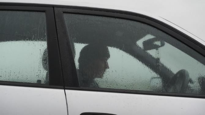 Graeme Obree seeks shelter from the rain at Machrihanish airport