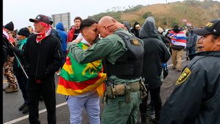 A demonstrator and a law-enforcement officer greet each other at Maunakea Access Road on July 22, 2019.