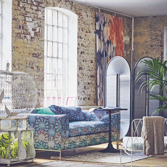 brick wall with white window and sofa with cushions