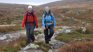 two women hiking in wet mountains