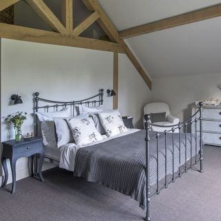 bedroom with wooden beams and carpet floor