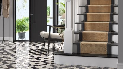 Grey narrow staircase with tongue and groove panelling on either side and exposed stone on the landing wall 