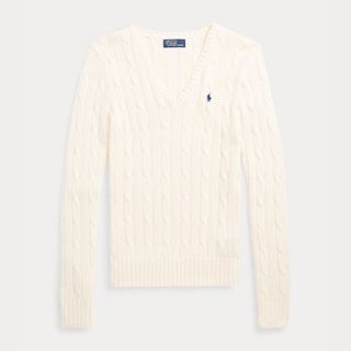 A cutout of a cream cable knit v neck jumper