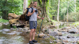 Solo man traveling backpacker hiking a river