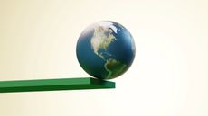 Conceptual image of the earth about to fall off the edge of a green plank 