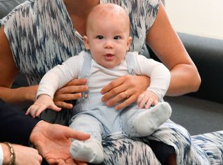 Prince Archie as a baby sat on Meghan Markle's knee
