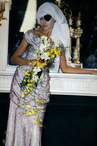 model dressed in pirate eye patch and white dress