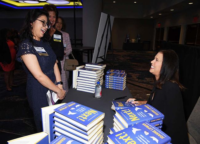 Author Joanne Lipman (r.) signs books for attendees of the WICT Network Leadership Conference at Manhattan&rsquo;s Marriott Marquis.