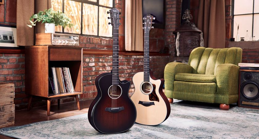 Taylor Next Generation Grand Auditorium: the two refreshed cutaway electro-acoustic guitars are photographed in front of a green sofa and a vintage hi-fi unit.