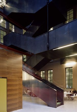 Oslo's National Library by Longva Architects, Norway. A wooden staircase going up multiple levels with walkways on them.