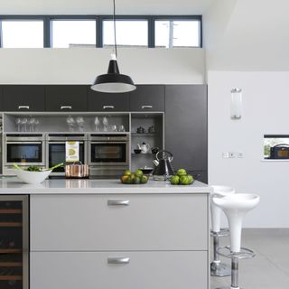 minimalist monochrome kitchen with island, bar stools and lighting
