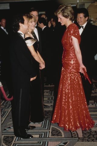 Princess Diana wears a red evening dress and talks to Billy Crystal and Meg Ryan at the premiere of Harry and Sally.