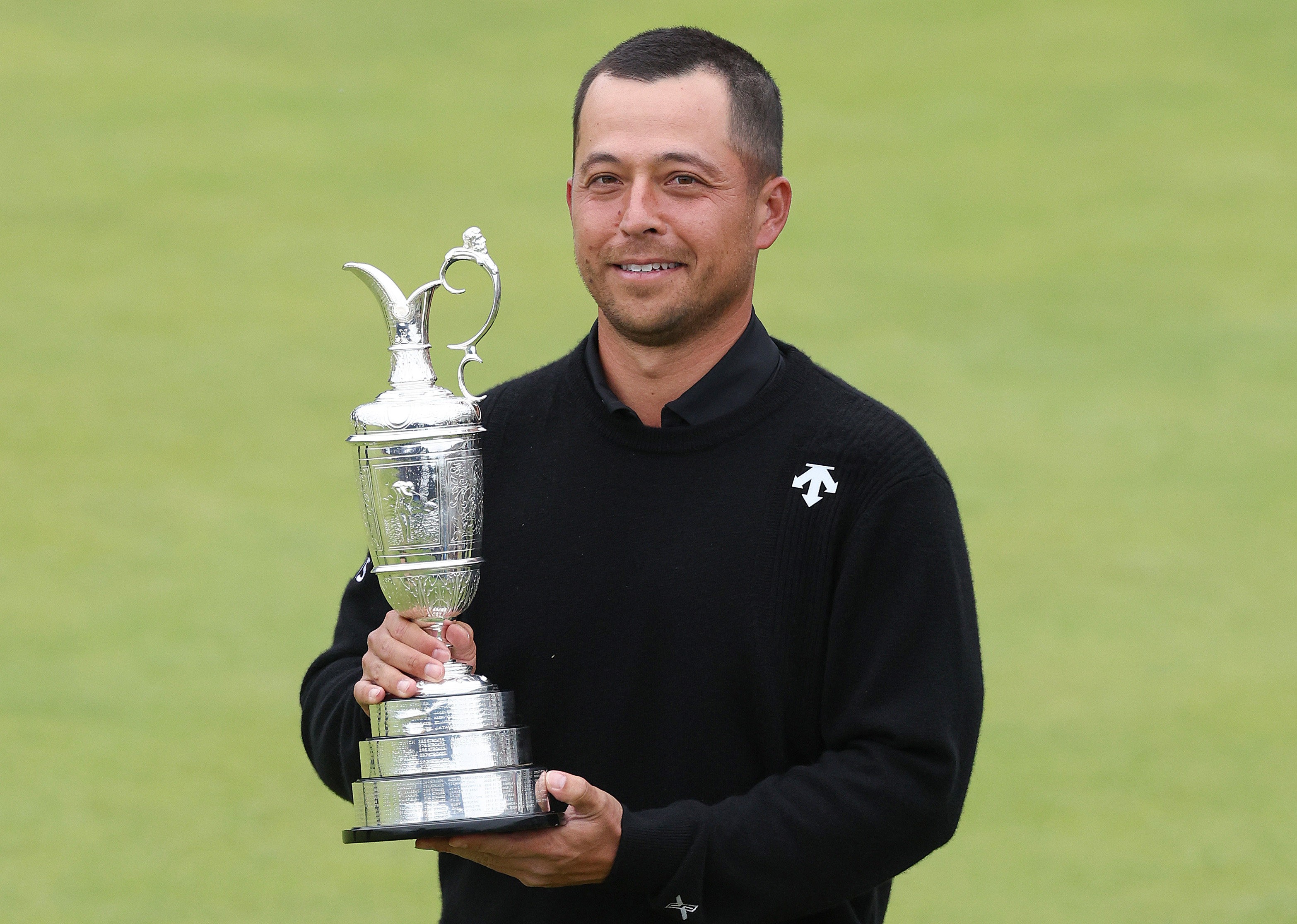 Xander Schauffele poses with the Claret Jug on the 18th hole in celebration of victory after the final of The 152nd Open championship.