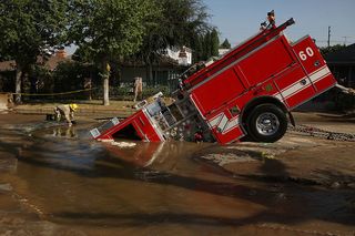 A 22-ton Los Angeles Fire Department fire truck protrudes from a sinkhole on September 8, 2009 in the Valley Village neighborhood of Los Angeles, California.