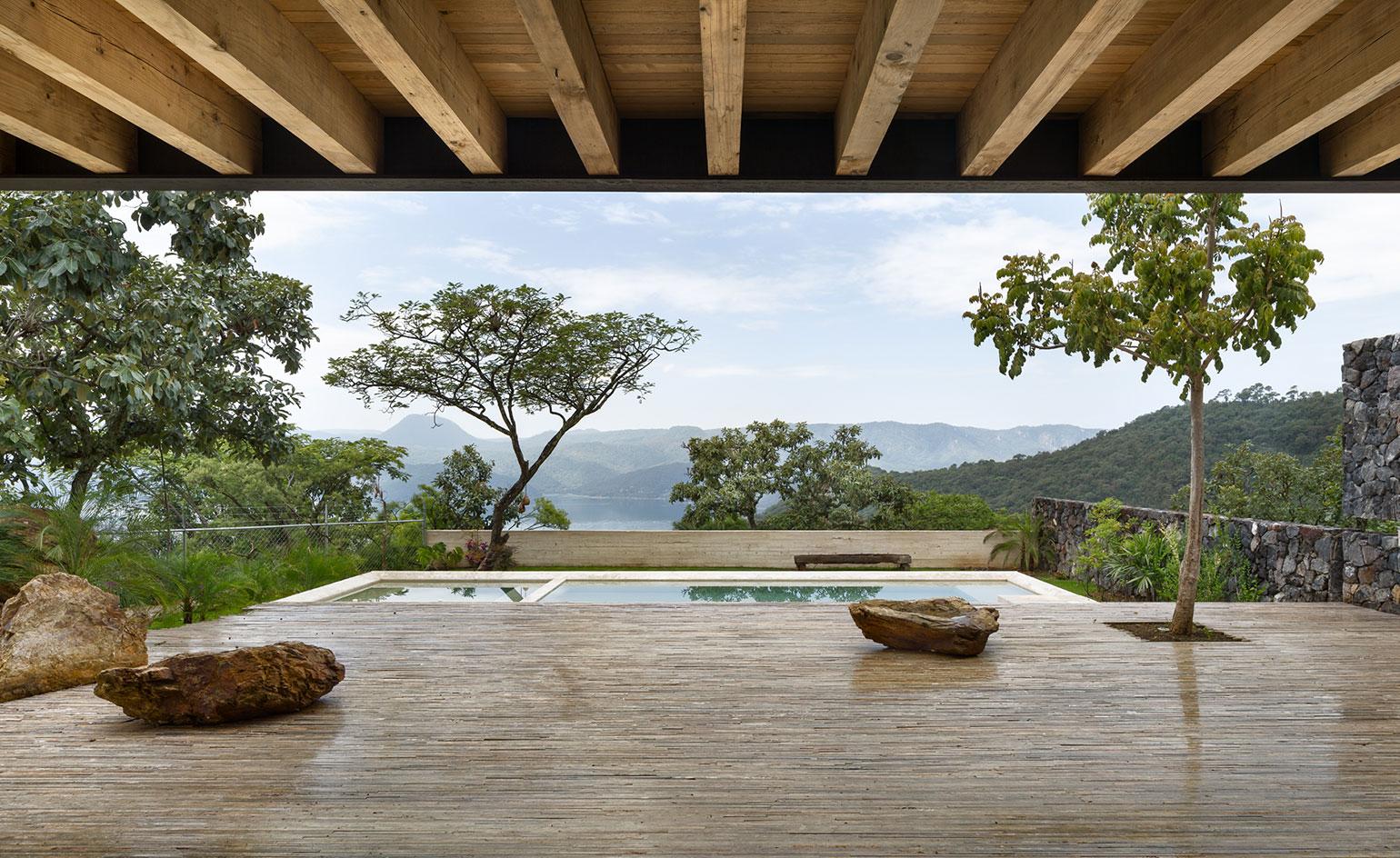The cantilevering roof juts out over the open plan living spaces, framing the dramatic views of Lake Avándaro