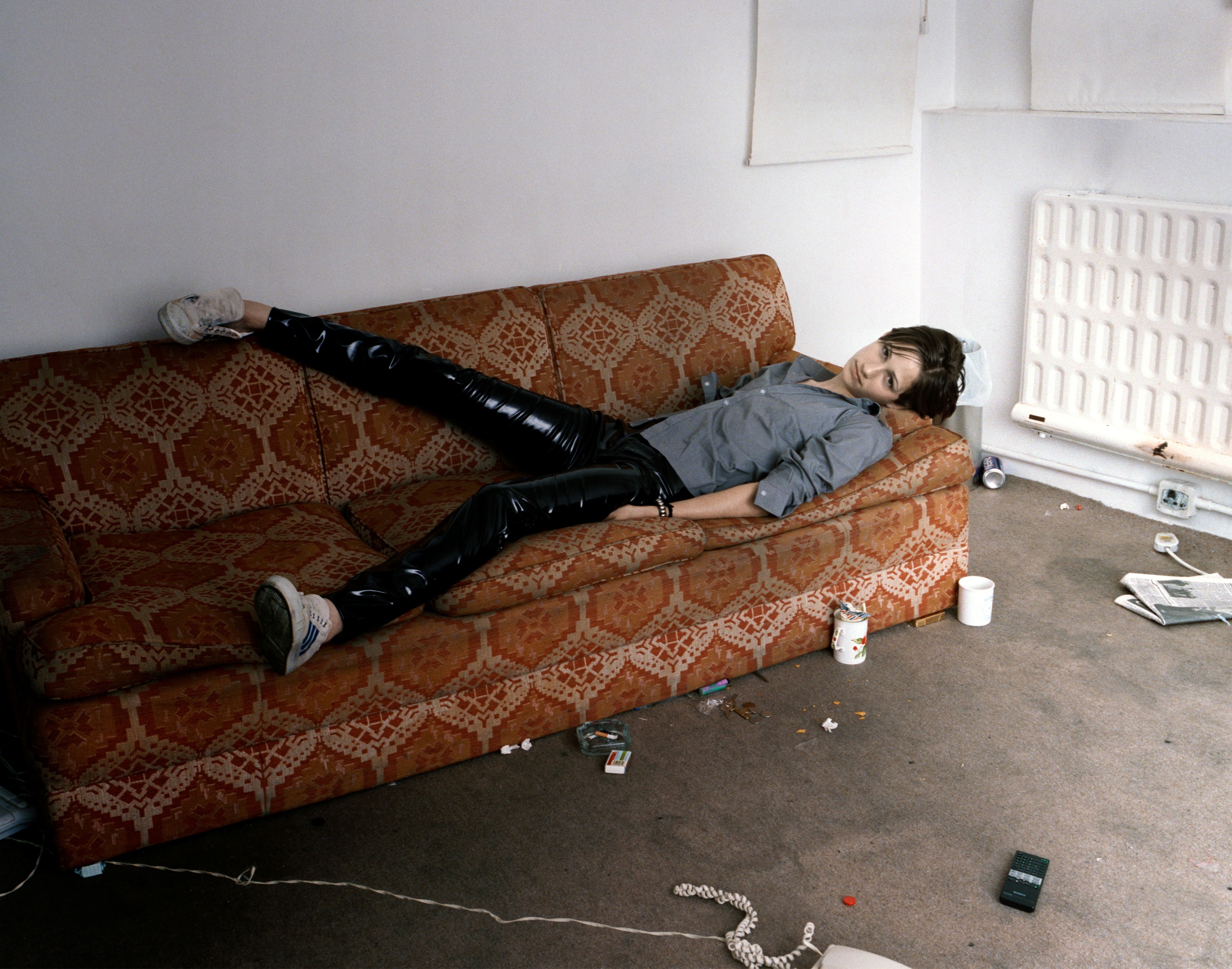 Corinne Day's England's Dreaming photograph of a young girl strewn across a coach in a room covered in the mess and dirt of a party prior