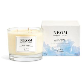 NEOM Real Luxury Scent to Destress Candle in glass vessel with sky blue and white cardboard box packaging