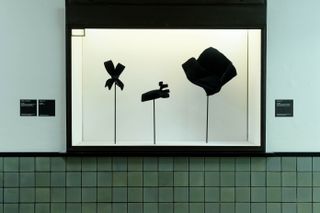 ‘Balenciaga in Black’ at Kunstmuseum Den Haag. A white display case on a wall with clothing accessories in it.