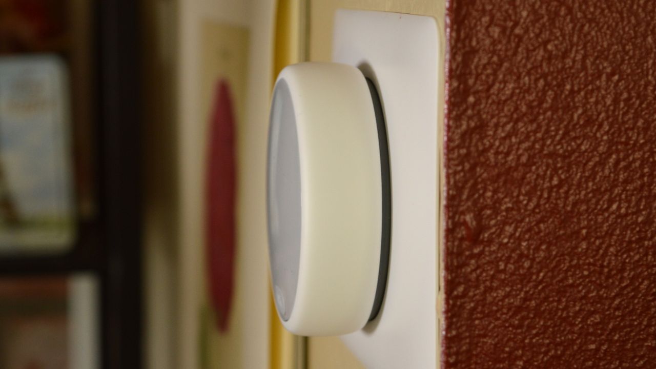 Side view of of Nest Thermostat E mounted on wall, showing how far its circular case protrudes into the room