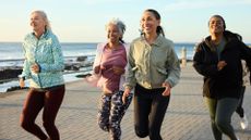 A group of women laughing and smiling, running in perimenopause