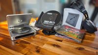 Fiio and Fosi Audio CD players on a table with headphones and CDs