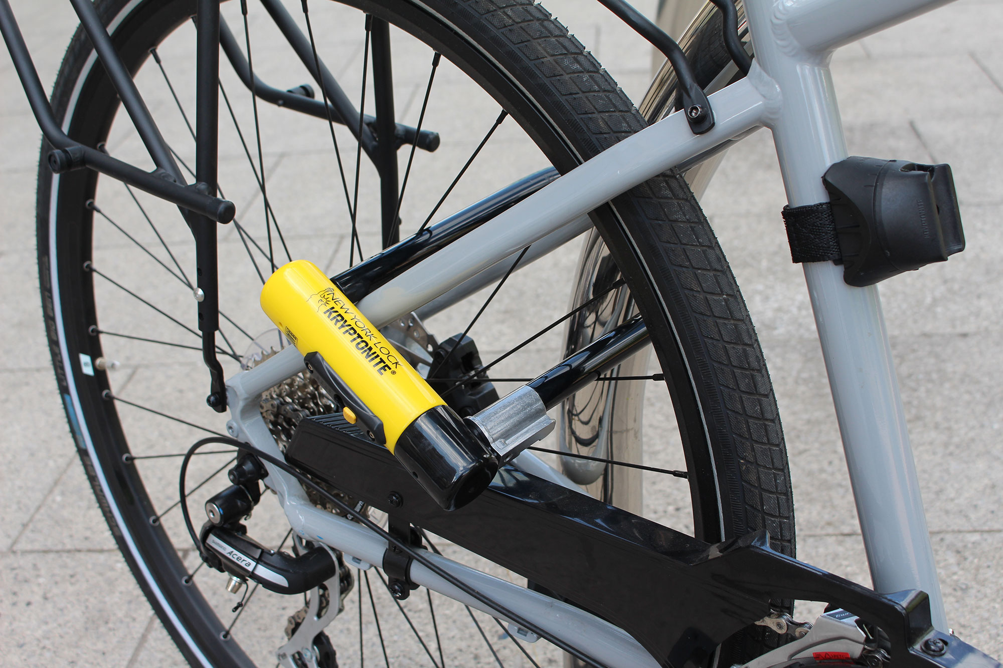 A classic D-lock/U-lock used to secure a bicycle frame and rear wheel to a post