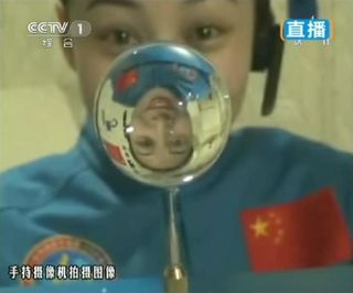 This screengrab from television taken on June 20, 2013 shows female astronaut Wang Yaping, one of the three crew members of Shenzhou-10 spacecraft, making a water ball in space during a lecture to students on Earth, aboard China's space module Tiangong-1.