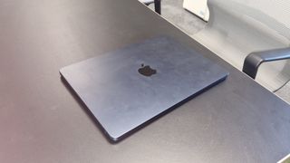 Laptop vs tablet; a photo of a MacBook Air laptop in an office on a black desk