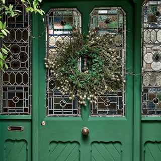 Green front door with green Christmas wreath